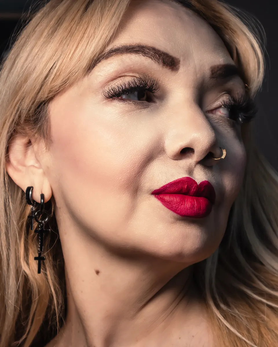 Retrato de una modelo de Crudo Studio con labios rojos sobre fondo oscuro